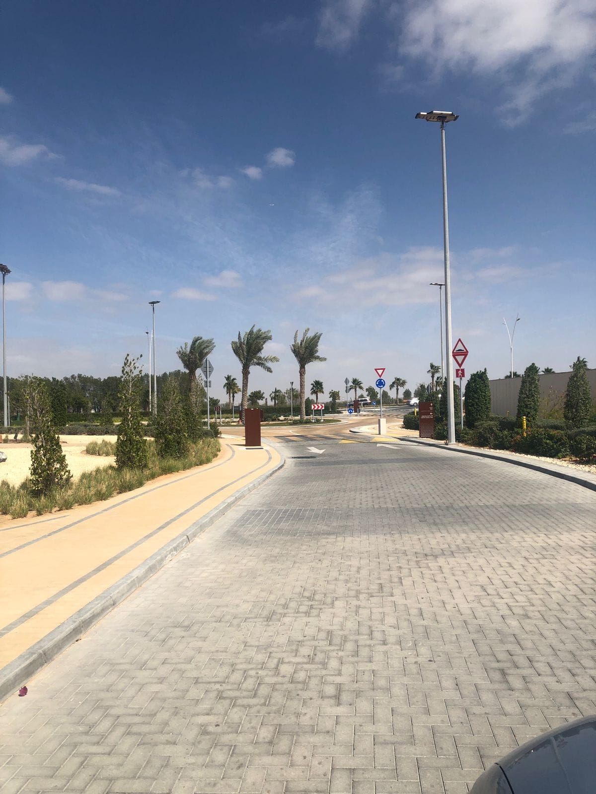 Interlock-paved road with kerbs, landscaping and street lighting at Yas Acres Golf Club